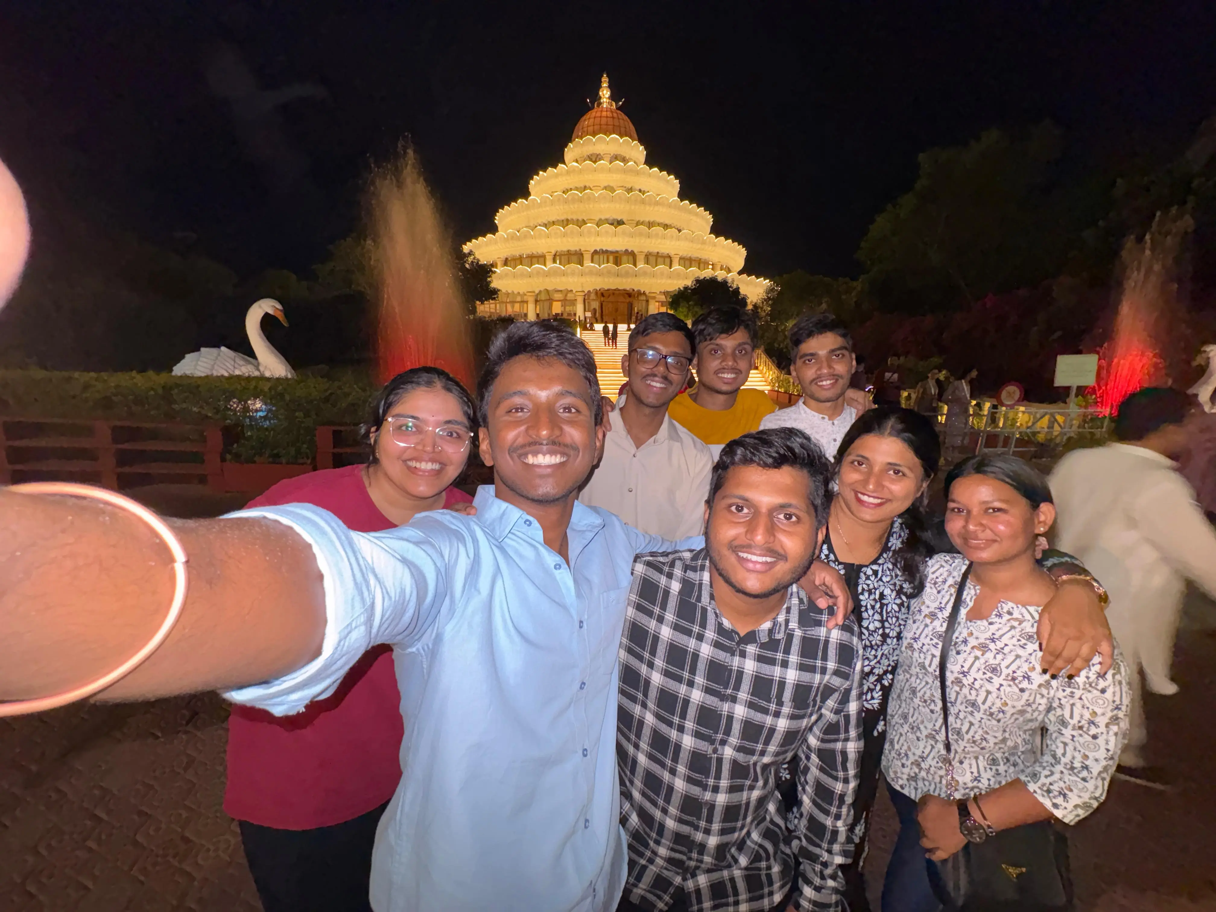 Candid selfie group shot at night in front of the illuminated structure