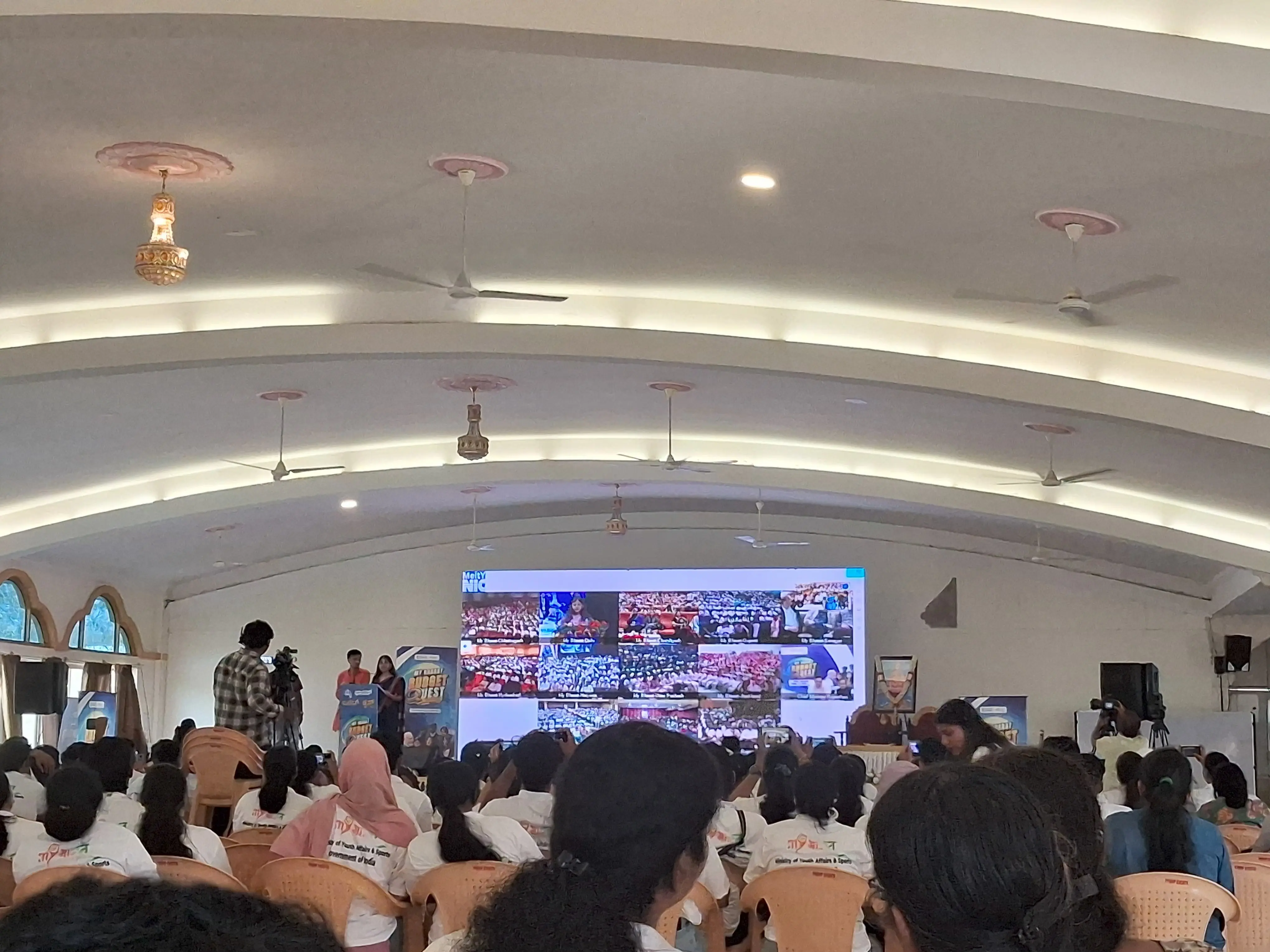 Wide shot of the indoor auditorium during the virtual interaction